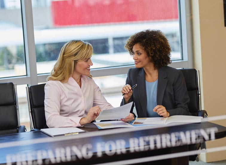 Two women seated at a table having a discussion.