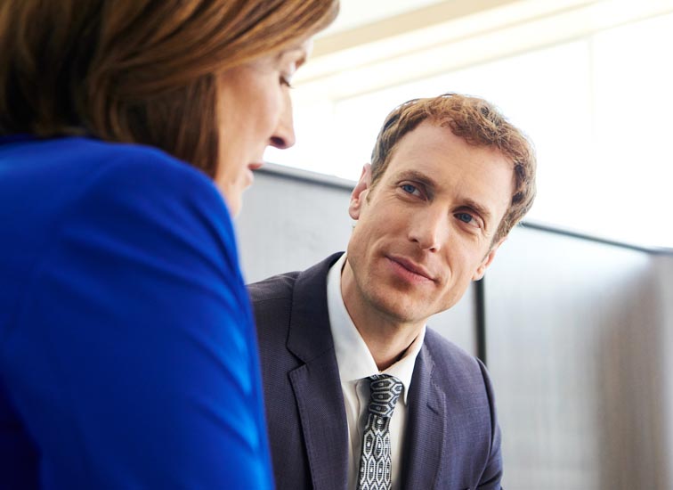 A man having a discussion with a woman in an office.