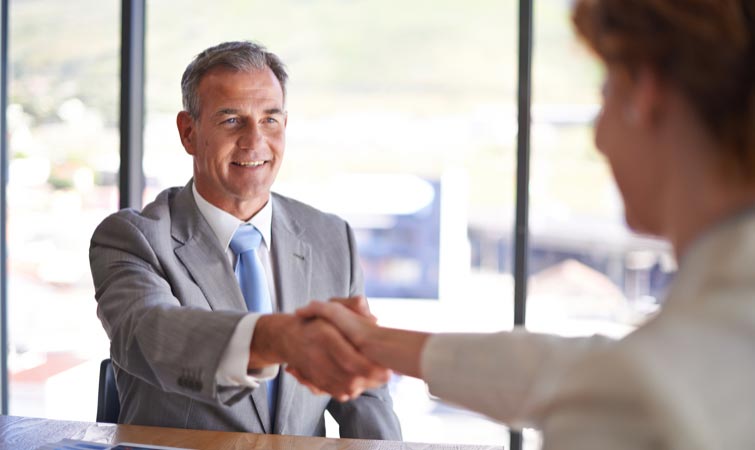 A financial advisor shaking the hand of another person