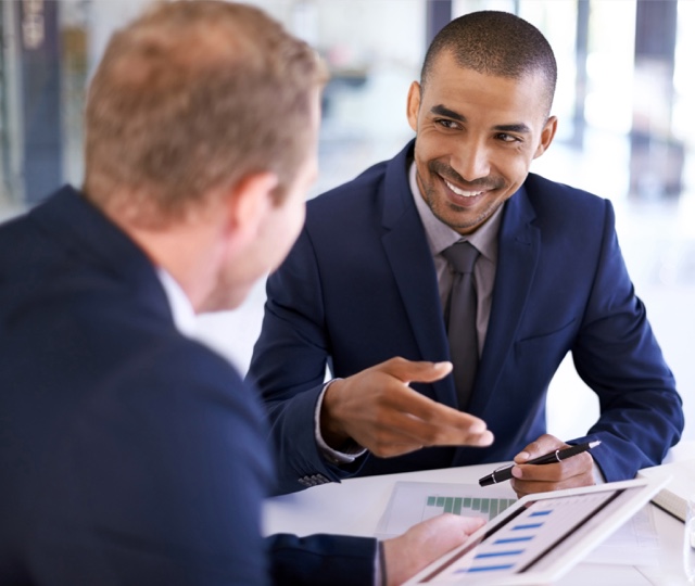 iStock-653383188-retouch-1 Businessmen working together on a digital tablet in an office