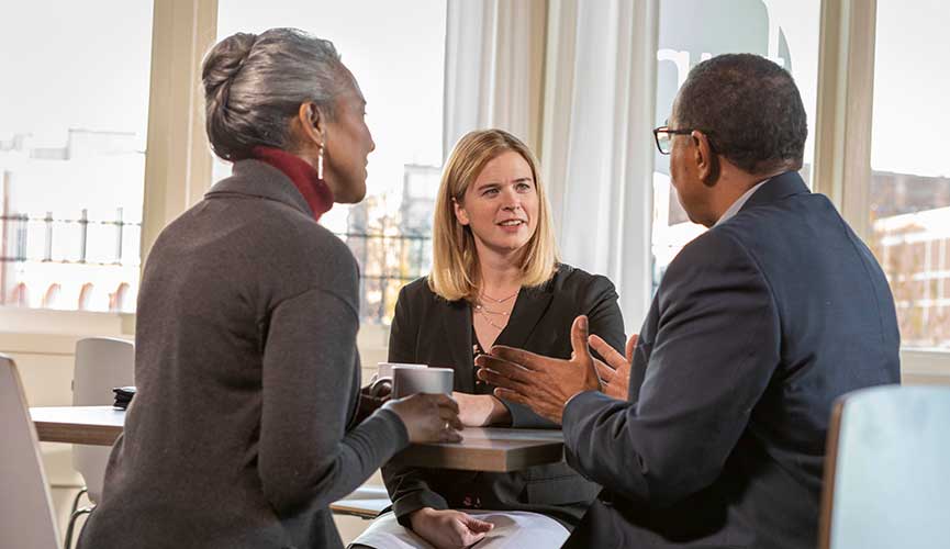 business-model-hero Woman conversing with couple over coffee